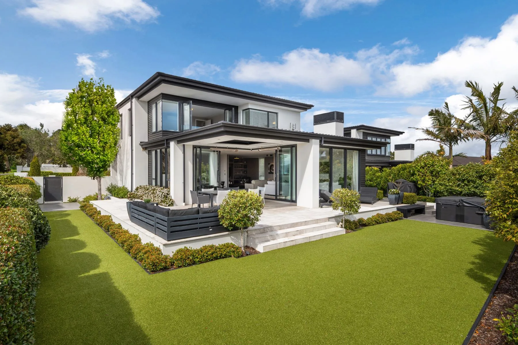Auckland home with a clipped lawn and planted borders