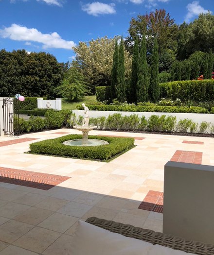 A fountain courtyard framed by clipped hedging